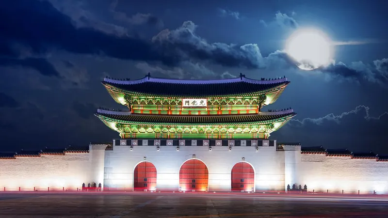 Local guide leading a couple past a royal palace gate on a seoul private tours custom walking day in Seoul, South Korea